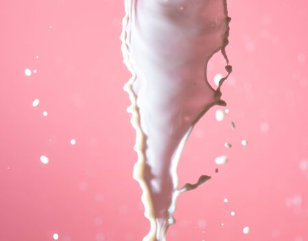 Splashes of white milk on a pink background. Drinkの写真素材
