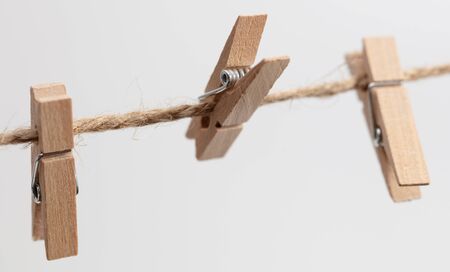 Clothespins hang on a rope on a white background.の写真素材
