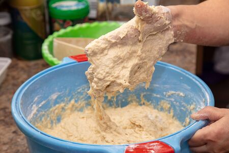 Hand stained in dough with flour. Cooking bread in the kitchen.の写真素材