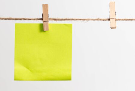 Colored papers hang on a rope on a white background.