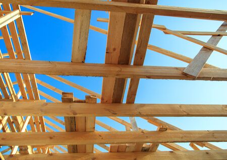 Wooden boards on the roof of the house against the sky. Home construction