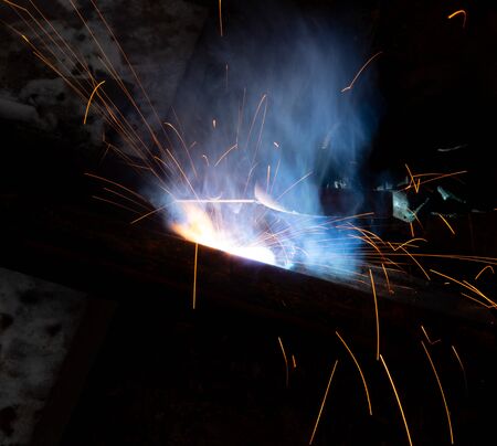 sparks from metal welding at a construction site.