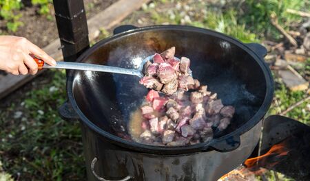 The meat is fried in oil in a cast-iron cauldron. Foodの写真素材