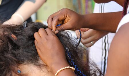 Girl braids blue African braids in a beauty salon.の写真素材