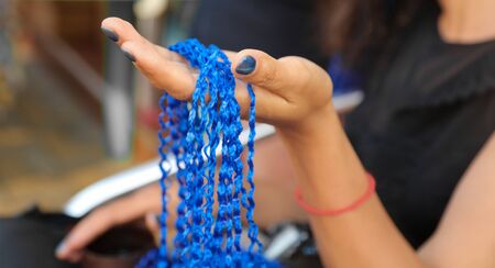 Threads for weaving. Girl braids blue African braids in a beauty salon.の写真素材