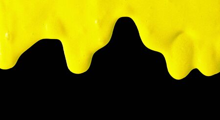 Yellow paint isolated on a black background.の写真素材