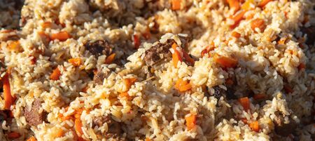 Pilaf with rice is cooked on a cast-iron cauldron. The dish is cooked at the stakeの写真素材