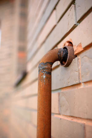 Gas pipe in a brick wall. Rusty metalの写真素材