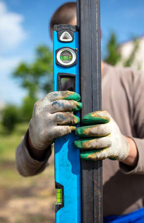Installation of metal in the soil for the gate on the fence.