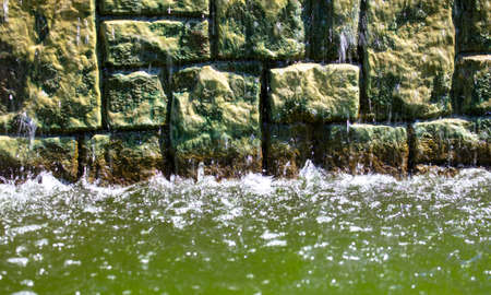 Water flows along a brick wall. Backgroundの写真素材