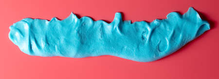 Blue slime isolated on pink background. Jelly-like material for children to play