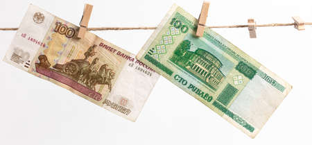 Belarusian rubles and Russian rubles hang on a rope on a white background. Moneyの写真素材