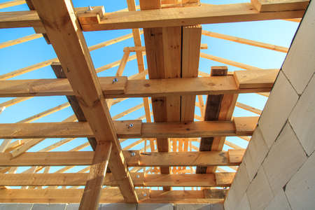 Wooden boards on the roof of the house against the sky. Home construction