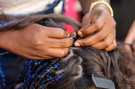 Girl braids blue African braids in a beauty salon.の写真素材