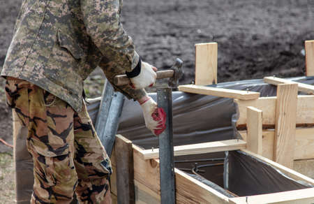 Work hammer hammers metal at a construction site at home. Pouring concreteの写真素材