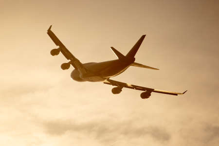Silhouette of an airplane at sunset.の写真素材