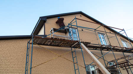 Installation of siding on the walls of the house. Construction worker