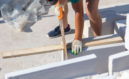 A worker saws a board with a saw. Technology