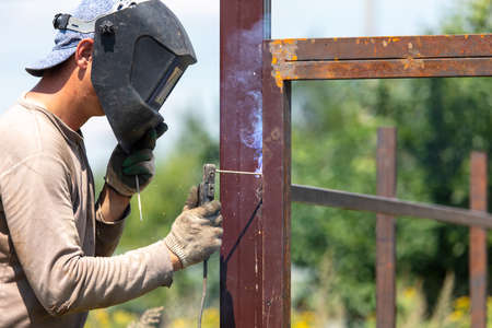 A worker welds metal for a fence. Technologyの写真素材