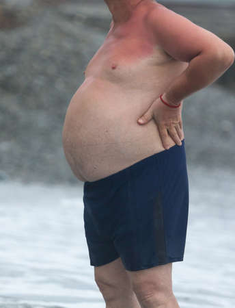 Big belly of a man on the sea.