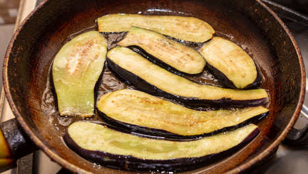Eggplants are fried in oil in a pan.の写真素材