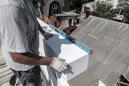 A worker builds the walls of a house from aerated concrete bricks. Technologyの写真素材
