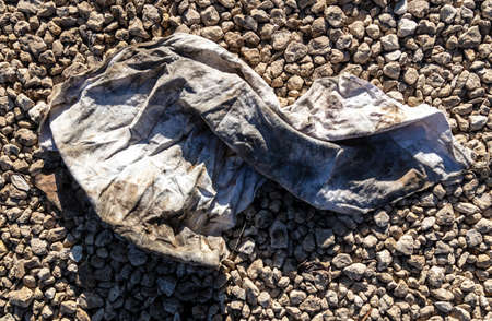 Dirty old wrinkled cloth on gravel stones.の写真素材