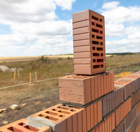 Bricks at the construction site of a house against the background of the sky with clouds.の写真素材