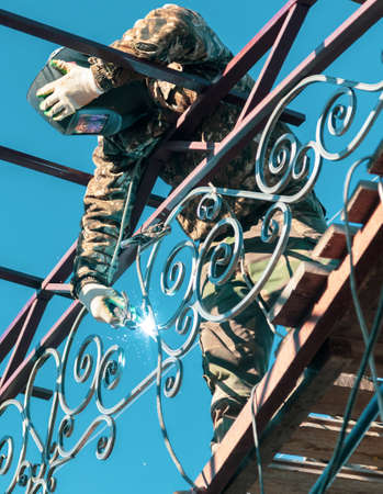 A worker welds metal onto the canopy frame. Technologyの写真素材