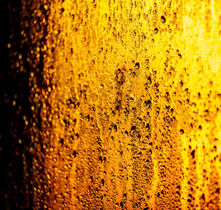 Drops of water on the glass of the window at sunrise as a background. Close-up