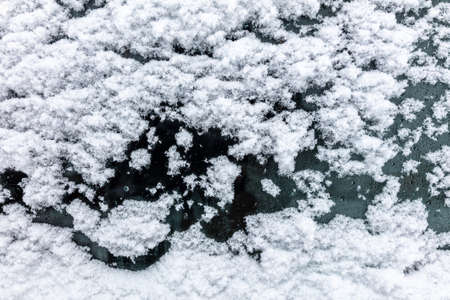 Snow on auto glass as background. Close-up