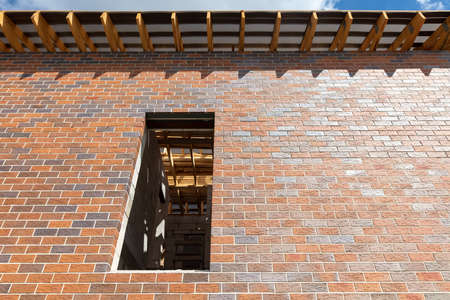 A window in a brick house under construction.