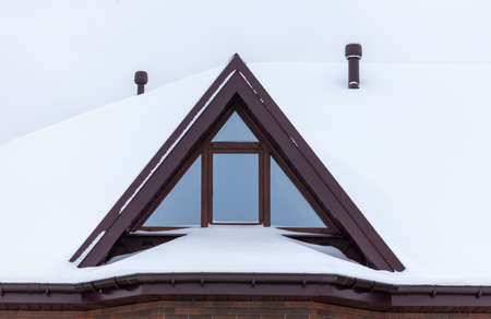 White snow on the roof of the house. Winter