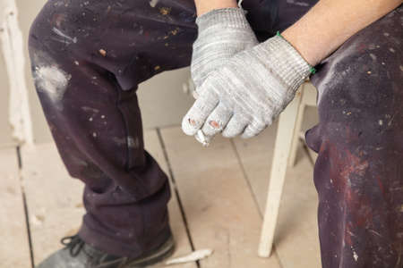 The worker holds a cigarette in his hands.の写真素材