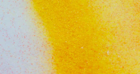 Yellow paint on the snow in winter. Abstract background.