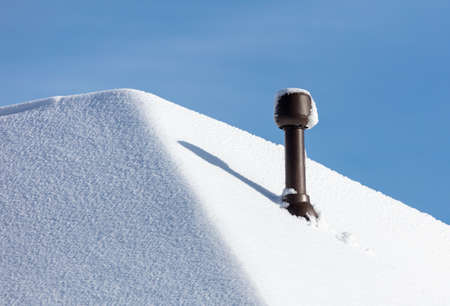 Snow on the roof of the house. Nature in winterの写真素材