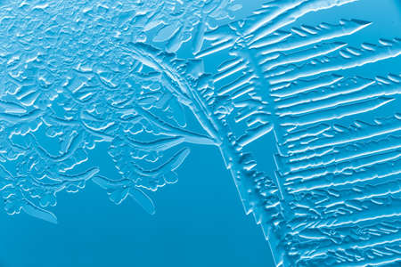 Blue patterns from frost on glass as a background. Close-up