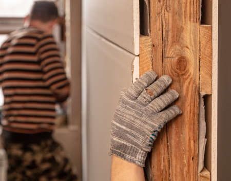 A worker installs drywall for a wall in a room. Repair.の写真素材