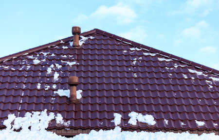Snow on the roof of the house. Nature in winterの写真素材