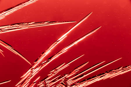 Red patterns from frost on glass as a background. Close-up