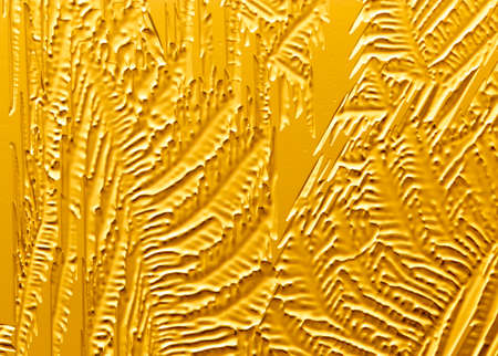 Gold patterns from frost on glass as a background. Close-up