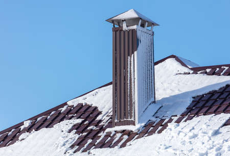 Snow on the roof of the house. Nature in winterの写真素材