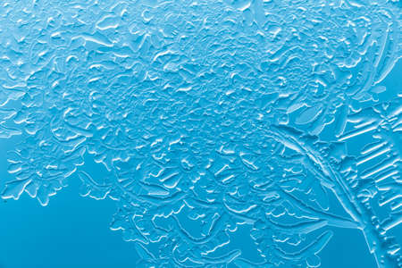 Blue patterns from frost on glass as a background. Close-up