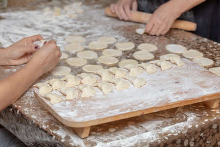 A girl and a woman make dumplings from dough. Cooking foodの写真素材