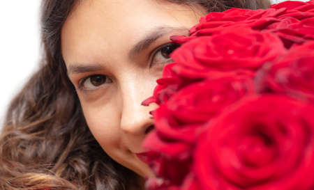 Girl with a bouquet of red roses isolated on a white background.の写真素材