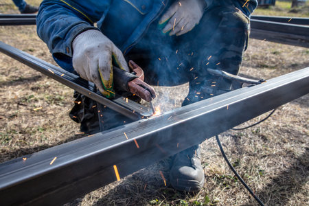 A worker welds metal at a construction site.