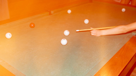 A man with a cue in his hands plays billiards on the table.の写真素材
