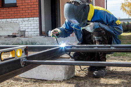 A worker welds metal at a construction site.