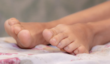 Girl's bare feet on the bed. Close-up