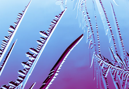 Blue-pink patterns from frost on glass as a background. Close-up